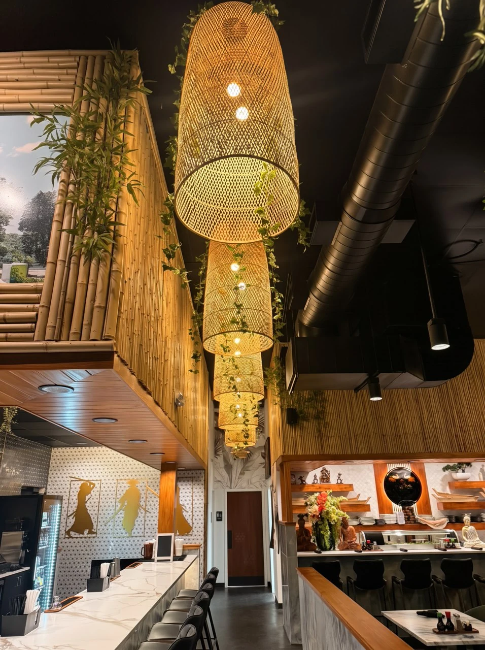 Woven bamboo lanterns glowing above the restaurant’s marble counter.